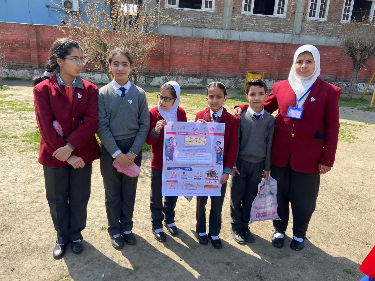 Students with National Deworming Day poster